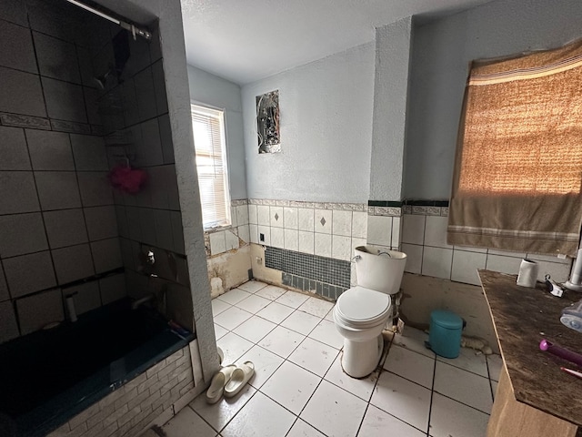 bathroom featuring toilet, tile walls, and tile patterned floors