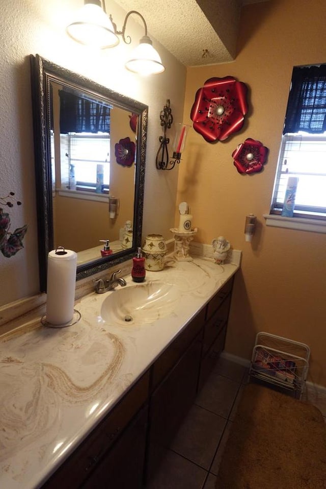 2511 Fontana St, Odessa, TX 79763 - bathroom featuring vanity, healthy amount of natural light, tile patterned flooring, and a textured ceiling