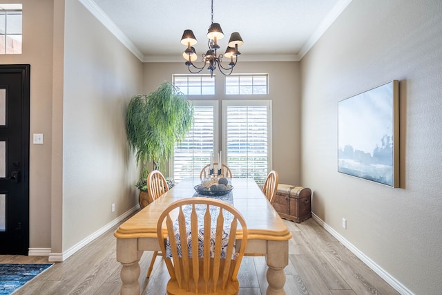 dining space featuring an inviting chandelier, baseboards, ornamental molding, and light wood finished floors