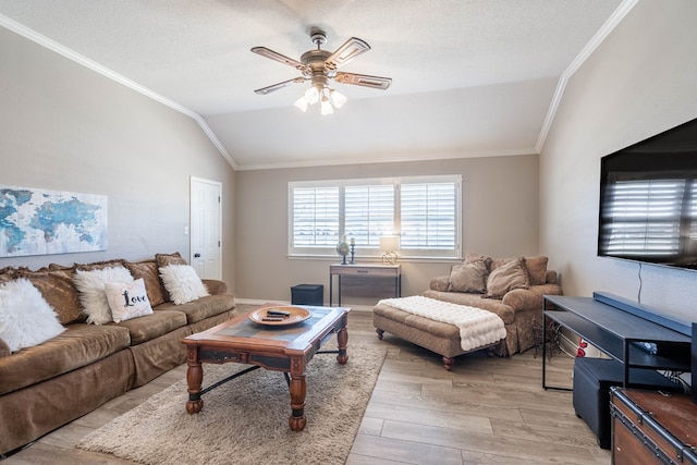 living area with ceiling fan, light wood-style flooring, ornamental molding, vaulted ceiling, and a textured ceiling