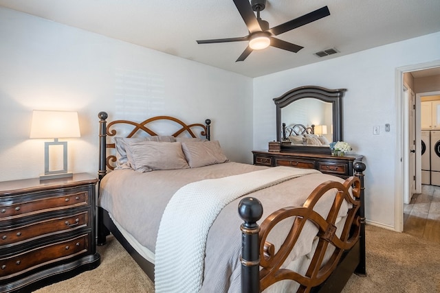 carpeted bedroom featuring washing machine and dryer, visible vents, and ceiling fan