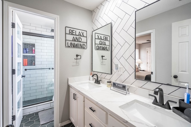 full bath featuring double vanity, a stall shower, tile patterned flooring, and a sink