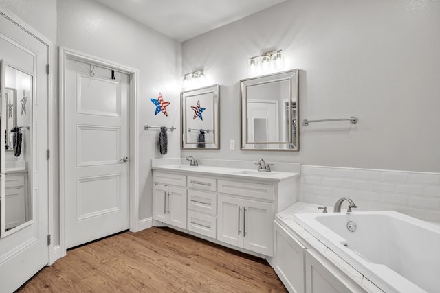 602 Frank Davis Ave, Coahoma, TX 79720 - bathroom featuring double vanity, a bath, and wood finished floors