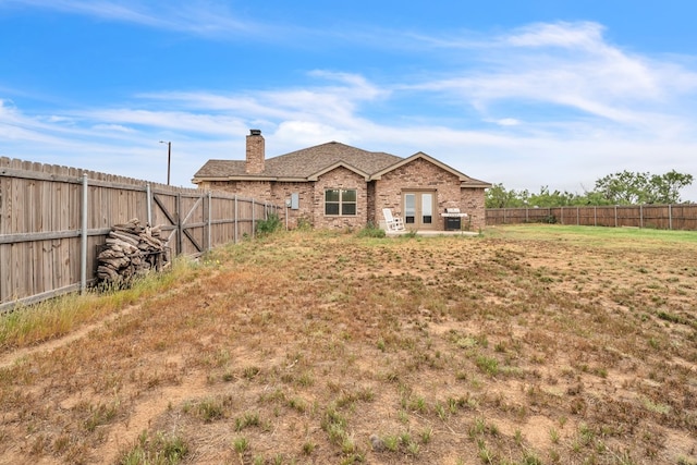 602 Frank Davis Ave, Coahoma, TX 79720 - rear view of house with a chimney, brick siding, and french doors