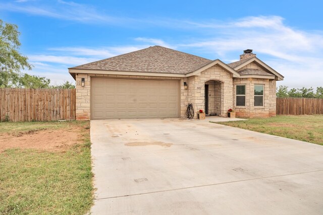602 Frank Davis Ave, Coahoma, TX 79720 - view of front of house featuring stone siding, a chimney, concrete driveway, an attached garage, and roof with shingles