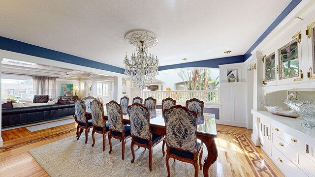 dining space with a notable chandelier and light hardwood / wood-style flooring