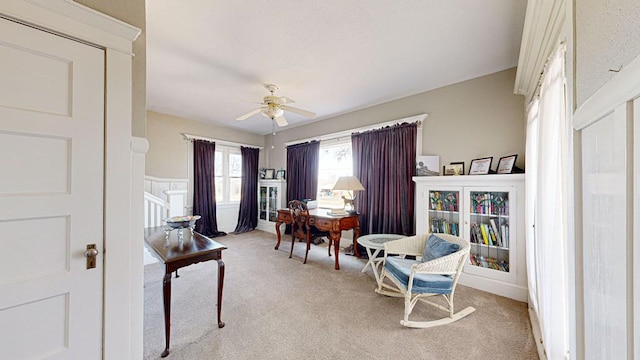 home office with light carpet and ceiling fan