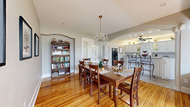 dining space featuring ceiling fan with notable chandelier and light wood-type flooring