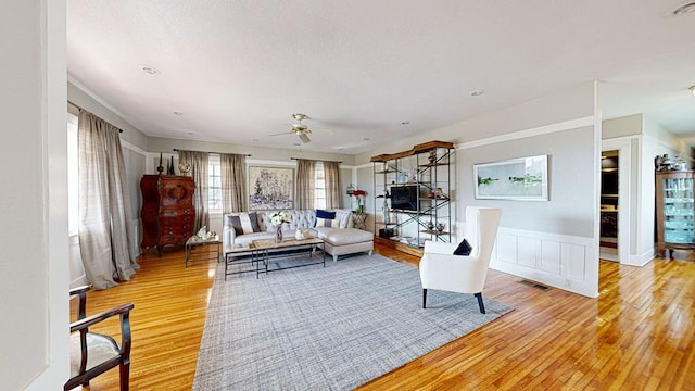 living room with light hardwood / wood-style flooring and ceiling fan