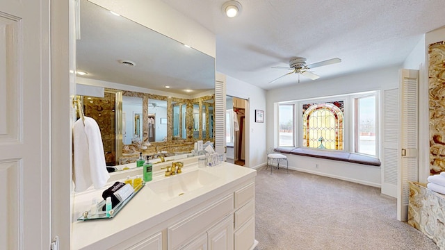 bathroom with vanity, ceiling fan, and a textured ceiling