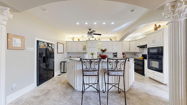 kitchen featuring backsplash, white cabinetry, a center island, and black appliances