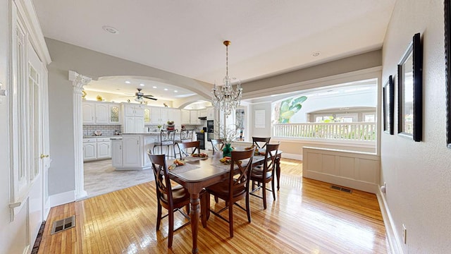 dining room featuring light hardwood / wood-style floors and ceiling fan with notable chandelier