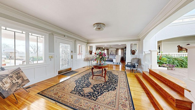 entryway with hardwood / wood-style flooring and crown molding