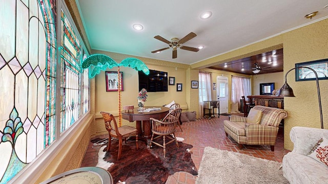 interior space featuring ceiling fan and ornamental molding