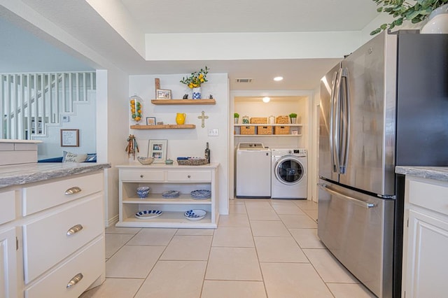 kitchen featuring white cabinetry, light tile patterned flooring, separate washer and dryer, and stainless steel refrigerator