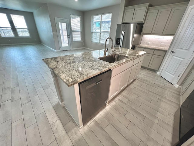 3108 Mearns Ct, Midland, TX 79705 - kitchen featuring appliances with stainless steel finishes, a sink, light wood-style floors, and healthy amount of natural light