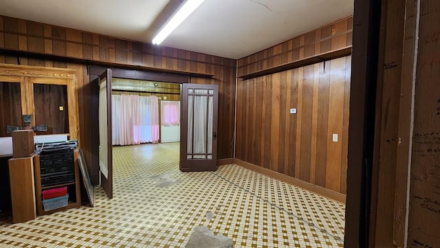 hall featuring wooden walls and light floors