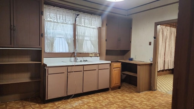 kitchen featuring light countertops, a sink, light floors, and open shelves