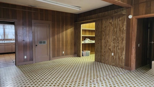 unfurnished room with a sink and wooden walls