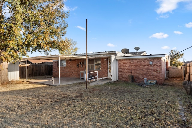 back of house with a yard and a patio