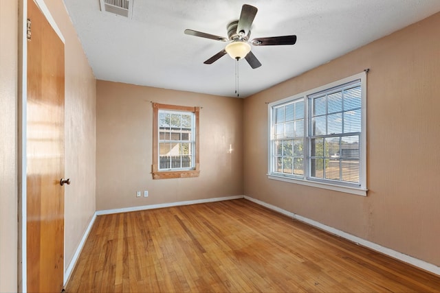 spare room with ceiling fan, a textured ceiling, and light wood-type flooring