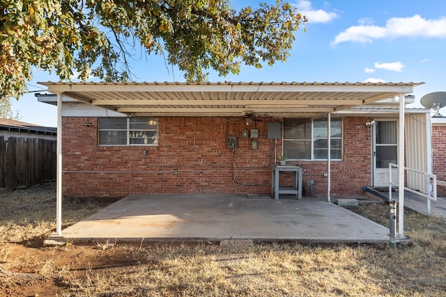 rear view of property featuring a carport and a patio area