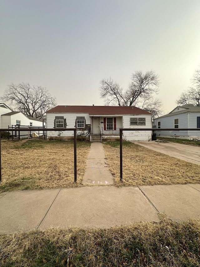 view of front of home with a front yard and fence