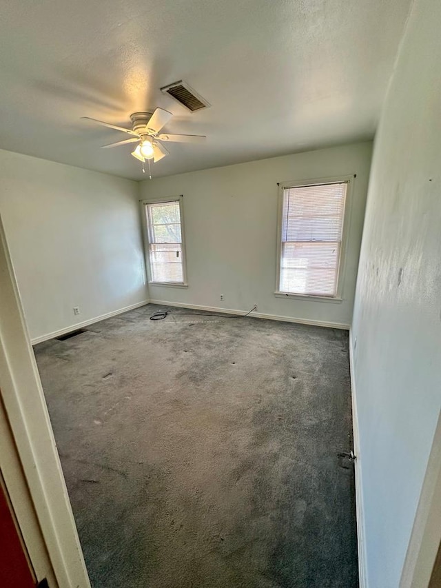 carpeted empty room with ceiling fan and a textured ceiling