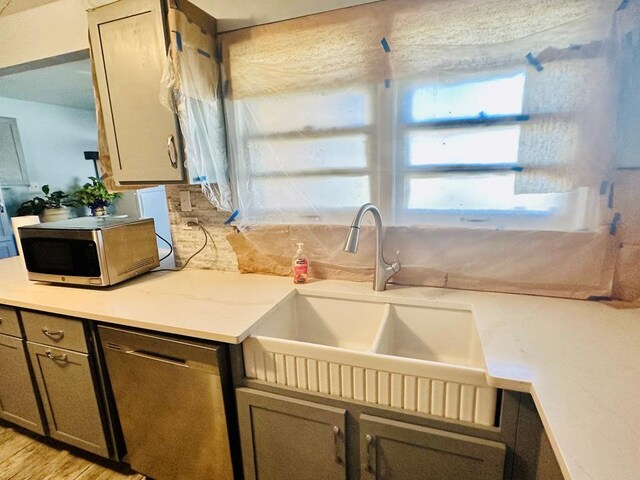 kitchen with decorative backsplash, stainless steel appliances, light hardwood / wood-style flooring, and sink