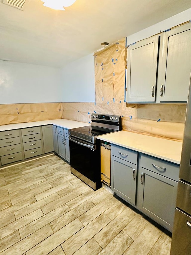 kitchen featuring tasteful backsplash, light hardwood / wood-style floors, and appliances with stainless steel finishes