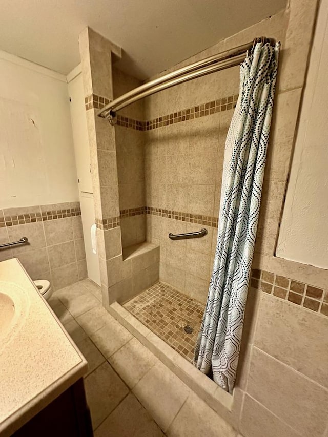 bathroom with tile patterned floors, vanity, curtained shower, and tile walls