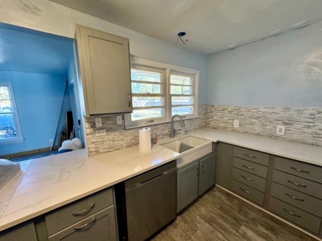 kitchen with gray cabinetry, dishwasher, sink, and tasteful backsplash