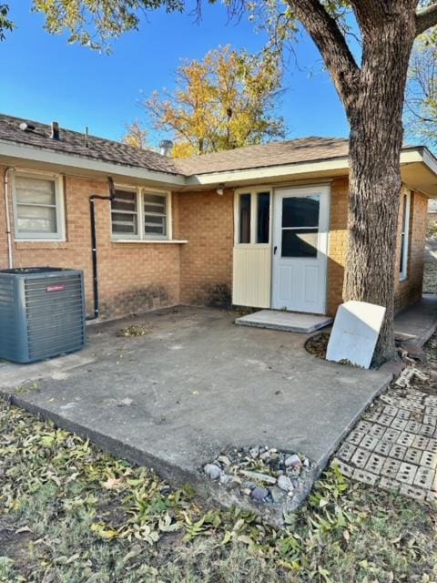 entrance to property featuring a patio and central air condition unit