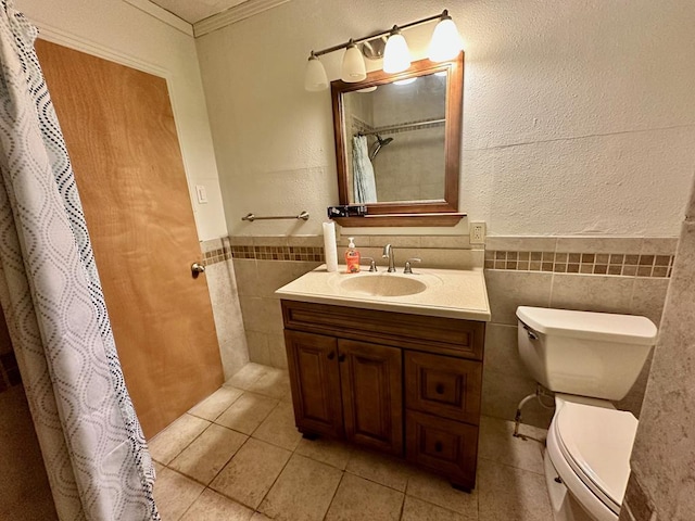 bathroom with vanity, tile patterned floors, toilet, ornamental molding, and tile walls