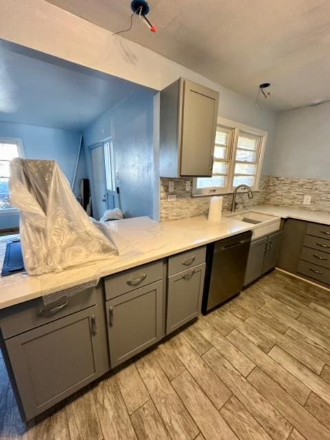 kitchen with backsplash, dishwasher, a healthy amount of sunlight, and sink