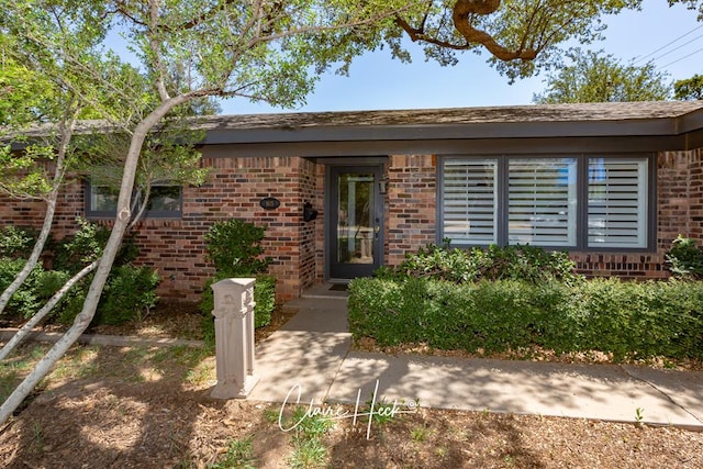 view of exterior entry featuring brick siding