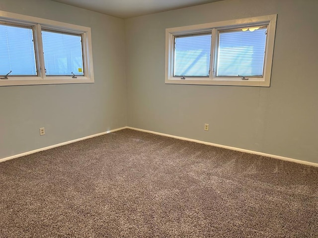 empty room featuring carpet floors and baseboards