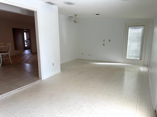 empty room with ceiling fan, a wealth of natural light, and visible vents