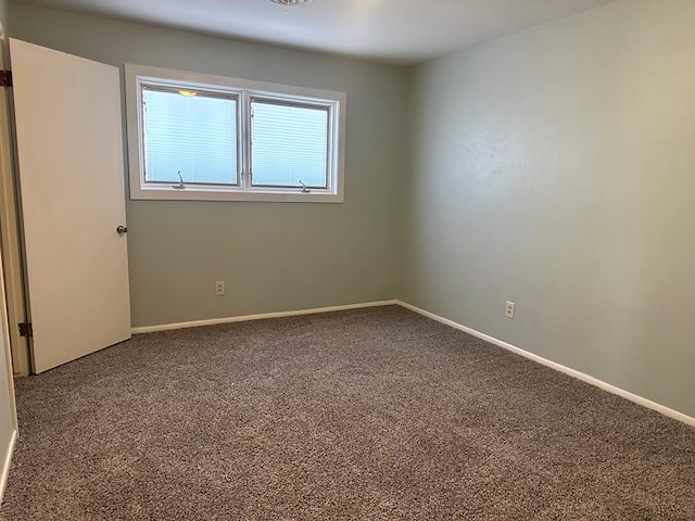 spare room featuring carpet floors and baseboards