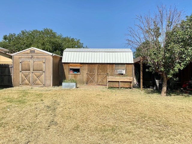 view of outdoor structure featuring cooling unit and a lawn