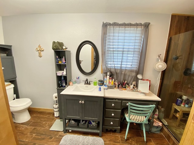 bathroom featuring toilet, vanity, and walk in shower