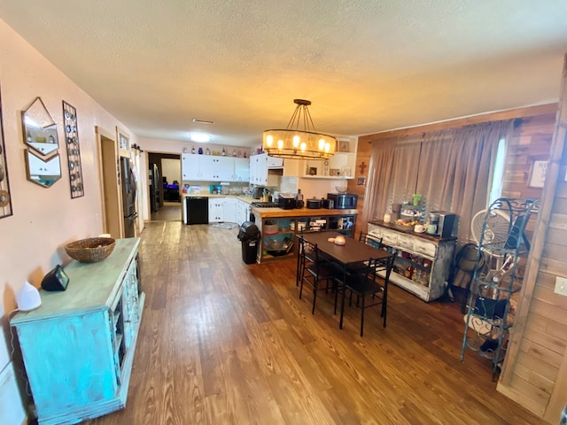 910 Culp Ave, Coahoma, TX 79511 - dining area featuring dark wood-style floors, a chandelier, and a textured ceiling