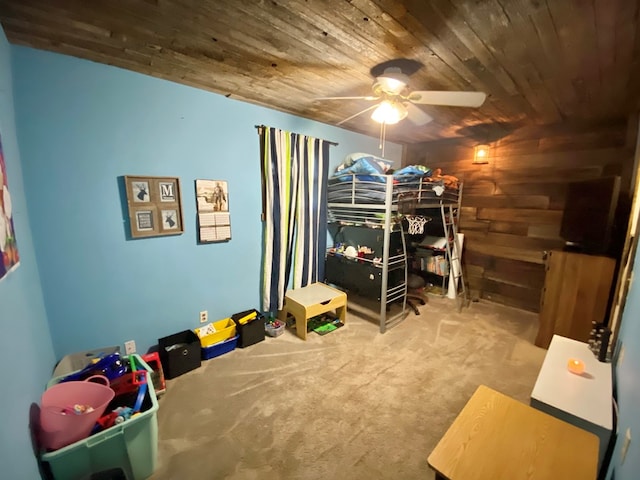 carpeted bedroom featuring ceiling fan, wooden walls, and wood ceiling