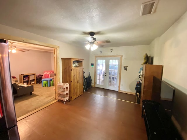 interior space with ceiling fan, french doors, hardwood / wood-style floors, and a textured ceiling