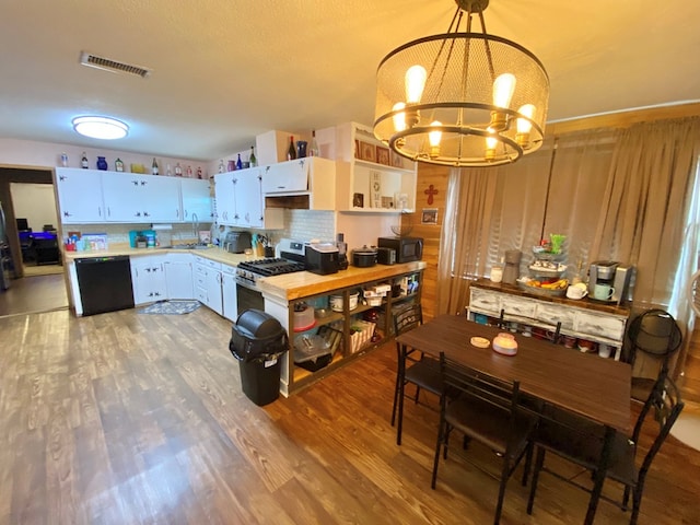 kitchen featuring gas stove, white cabinetry, black dishwasher, a chandelier, and pendant lighting