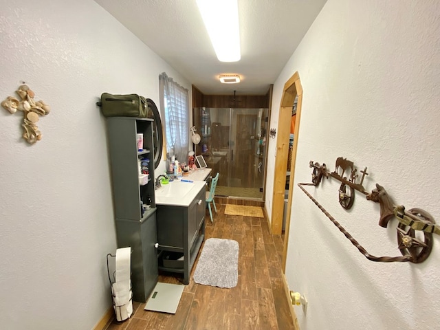 bathroom with a textured ceiling, vanity, hardwood / wood-style flooring, and a shower with shower door