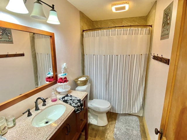 bathroom featuring hardwood / wood-style flooring, vanity, curtained shower, and toilet