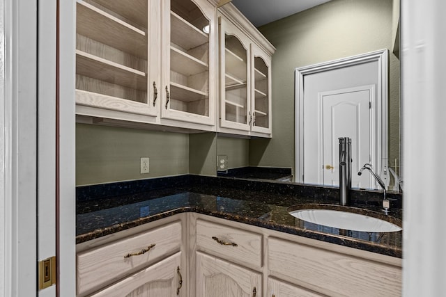 5708 Ridgemont Pl, Midland, TX 79707 - kitchen featuring glass insert cabinets, dark stone counters, and a textured wall