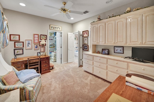 office area featuring ceiling fan, built in desk, and light carpet