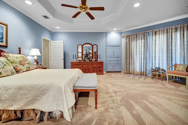 carpeted bedroom featuring ceiling fan, ornamental molding, and a tray ceiling